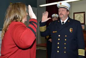 Chief Craig Haigh being swarn in by Hudson City Clerk Tracy Delaney as Commissioner Hutchings looks on